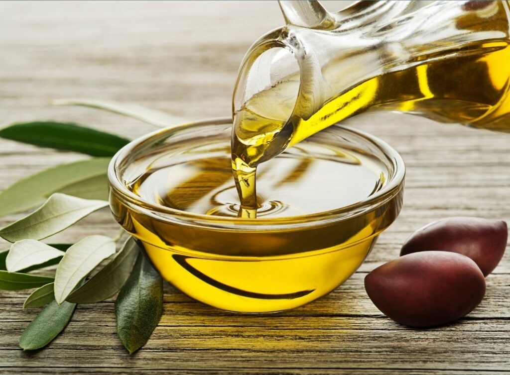 Pouring olive oil into a bowl, one of the 6 best anti-inflammatory oils to cook with