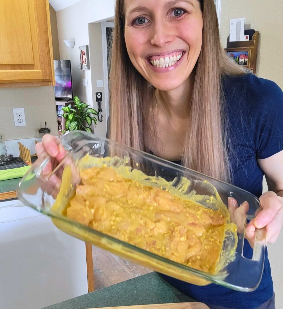 Author holding up a dish of the chicken strips in the Thai marinade