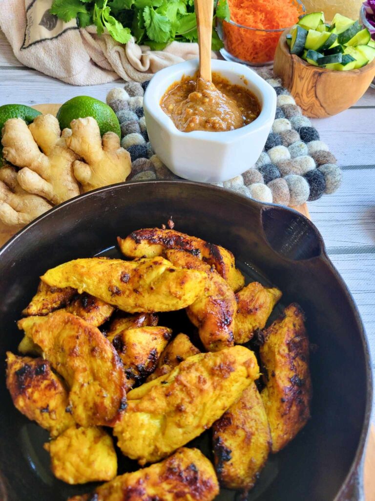 Thai Chicken with Almond Butter Sauce, ginger limes and other fresh veggies in the background
