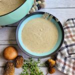 Dairy-free Cream of Mushroom soup in a bowl with fresh morels and thyme
