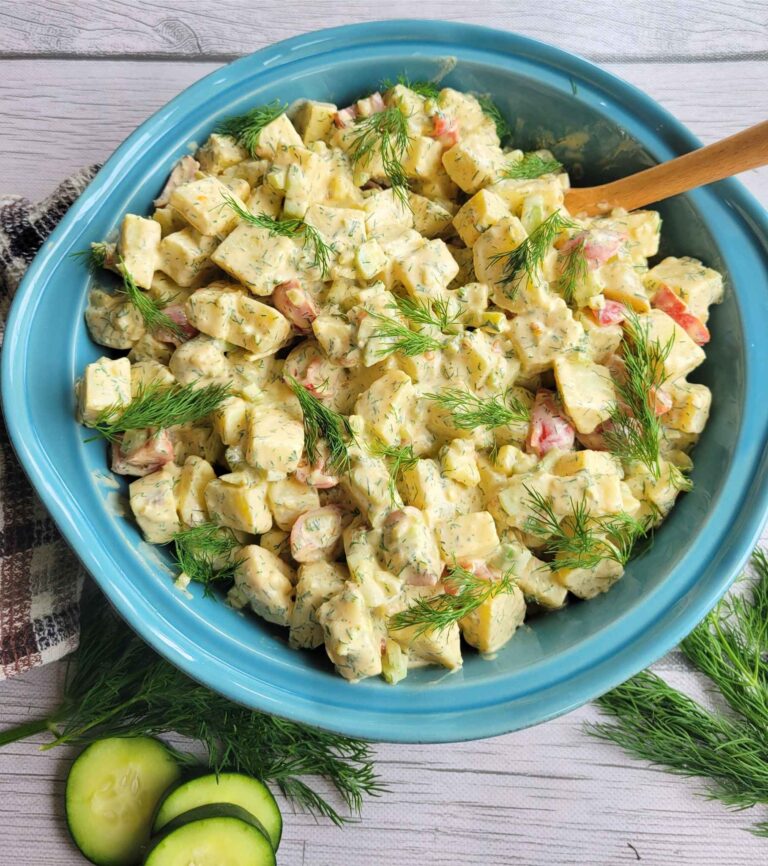 A serving bowl of classic sweet potato salad garnished wih fresh dill