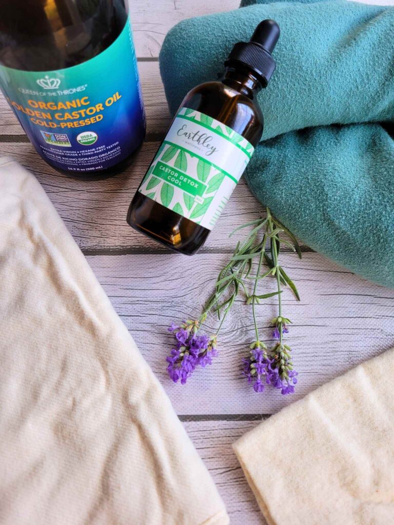 Materials for a DIY castor oil pack: cotton flannel cloth, castor oil, and a heating pad