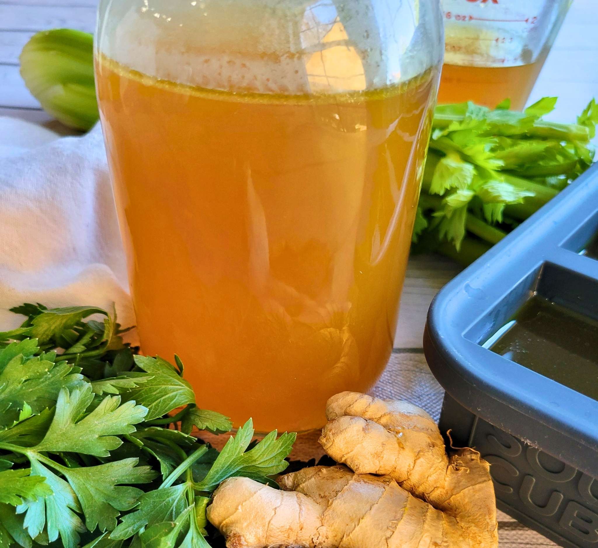A jar of this gut-healing homemade bone broth surrounded by fresh anti-inflammatory ingredients