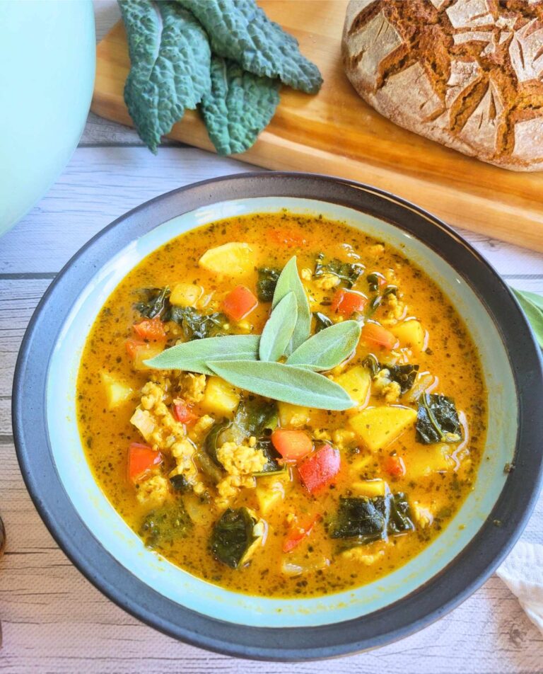 bowl of gut-healing pumpkin chicken soup with fresh sage garnish